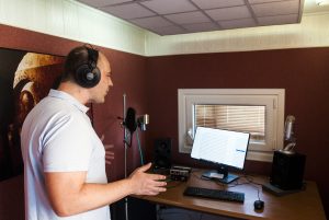 Locutor profesional grabando audiolibros en su estudio de grabacion